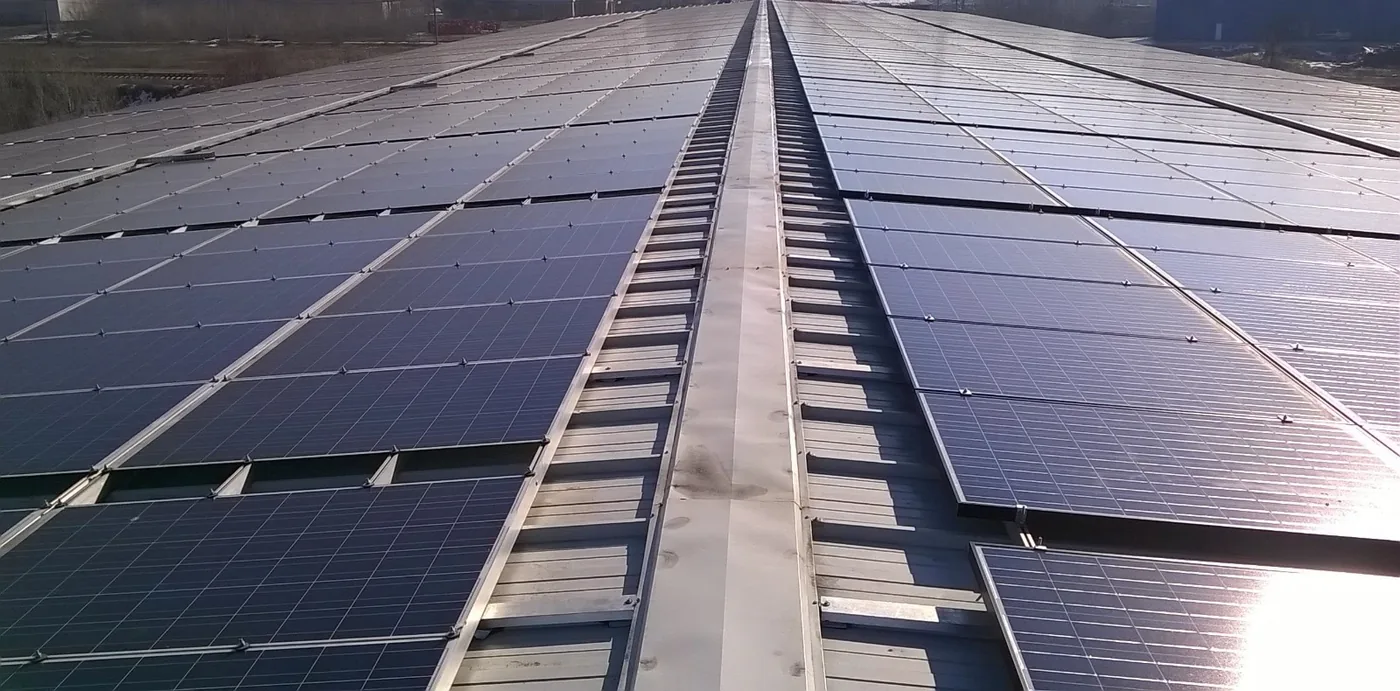 Rânduri de panouri fotovoltaice pe un acoperiș, văzute de aproape