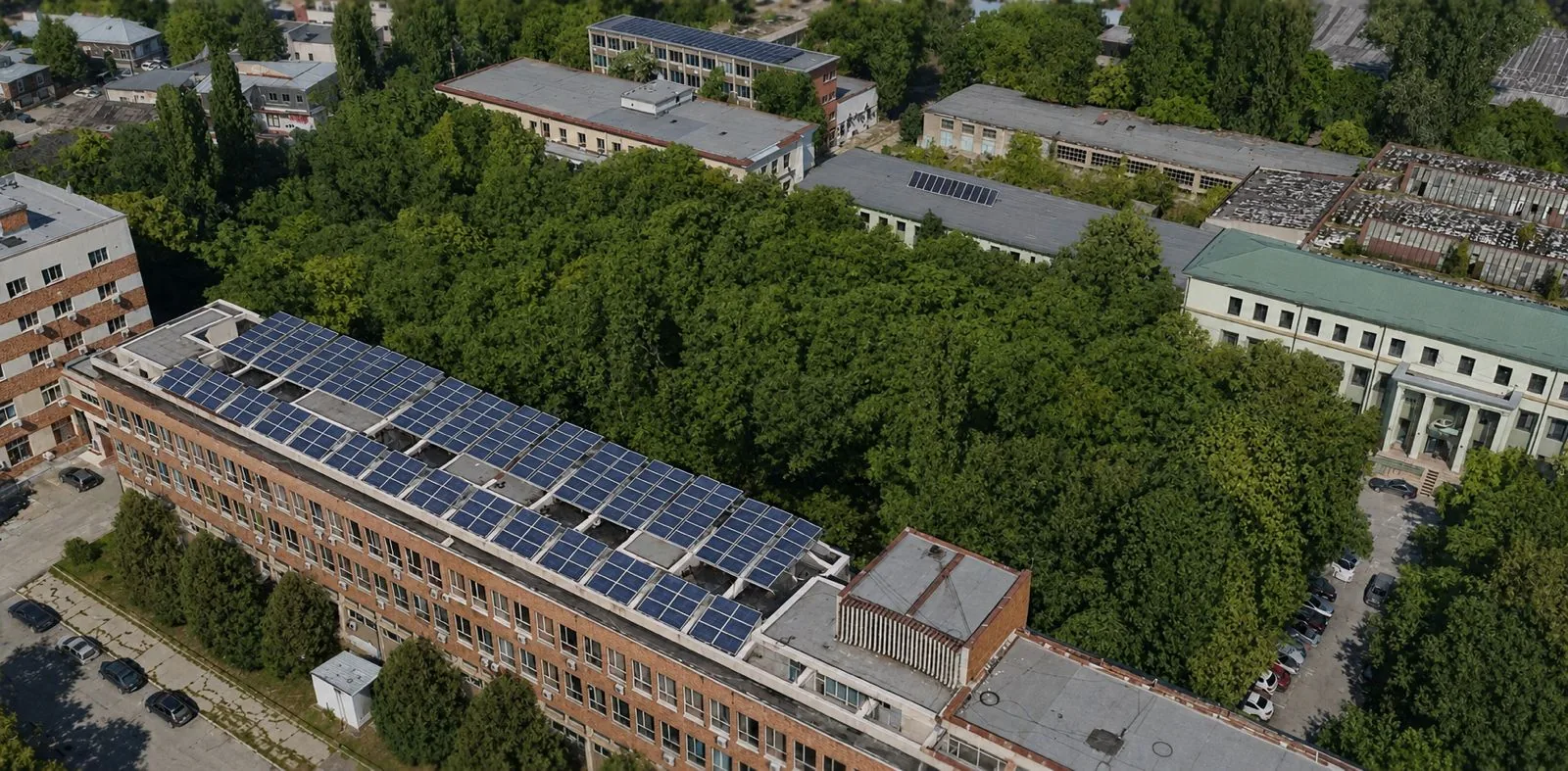 Ansamblu de clădiri văzut din dronă, cu panouri fotovoltaice pe acoperișuri