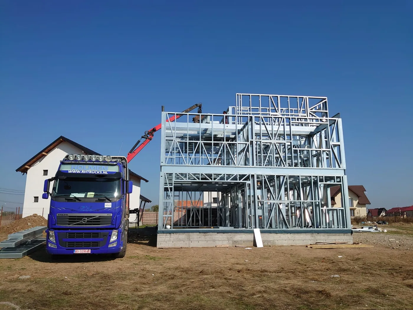 Camion de transport lângă structura montată a unei case